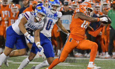 Sep 7, 2024; Champaign, Illinois, USA; Illinois Fighting Illini defensive back Xavier Scott (14) intercepts the ball in front of Kansas Jayhawks wide receiver Quentin Skinner (0) during the first half at Memorial Stadium. Mandatory Credit: Ron Johnson-Imagn Images