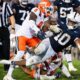 Penn State running back Nick Singleton (10) gets tripped up while carrying the ball in the fourth quarter of a Big Ten football game against Illinois, Saturday, Sept. 28, 2024, in State College, Pa.