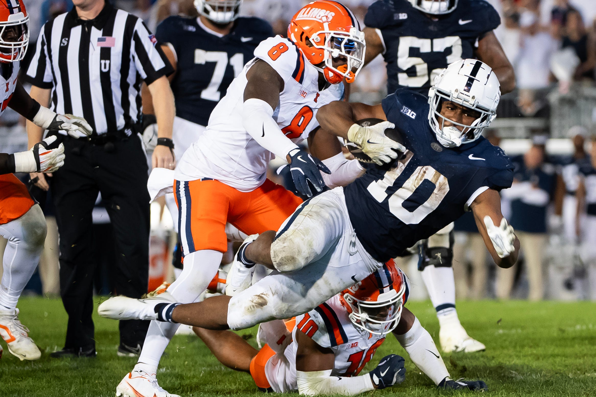 Penn State running back Nick Singleton (10) gets tripped up while carrying the ball in the fourth quarter of a Big Ten football game against Illinois, Saturday, Sept. 28, 2024, in State College, Pa.