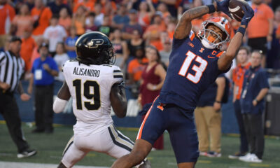 Illinois Fighting Illini wide receiver Pat Bryant (13) scores a touchdown catch over Purdue Boilermakers defensive back Botros Alisandro (19) in the second half at Memorial Stadium. Ron Johnson-Imagn Images