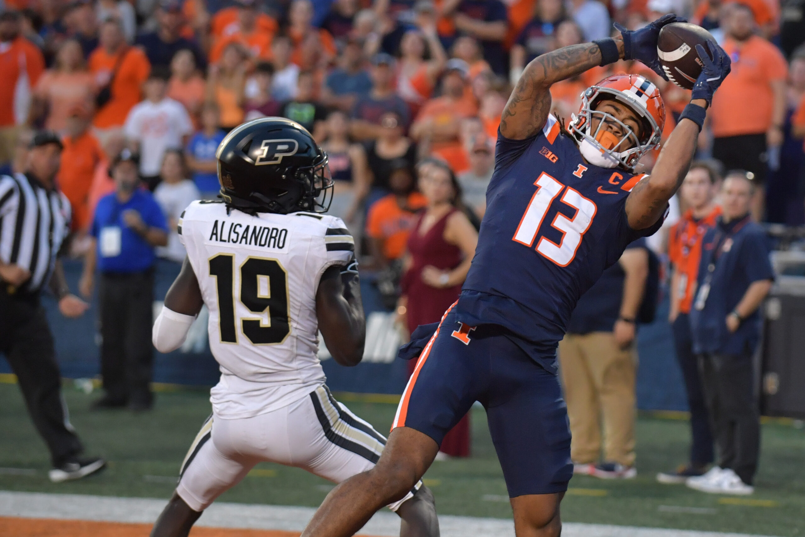 Illinois Fighting Illini wide receiver Pat Bryant (13) scores a touchdown catch over Purdue Boilermakers defensive back Botros Alisandro (19) in the second half at Memorial Stadium. Ron Johnson-Imagn Images