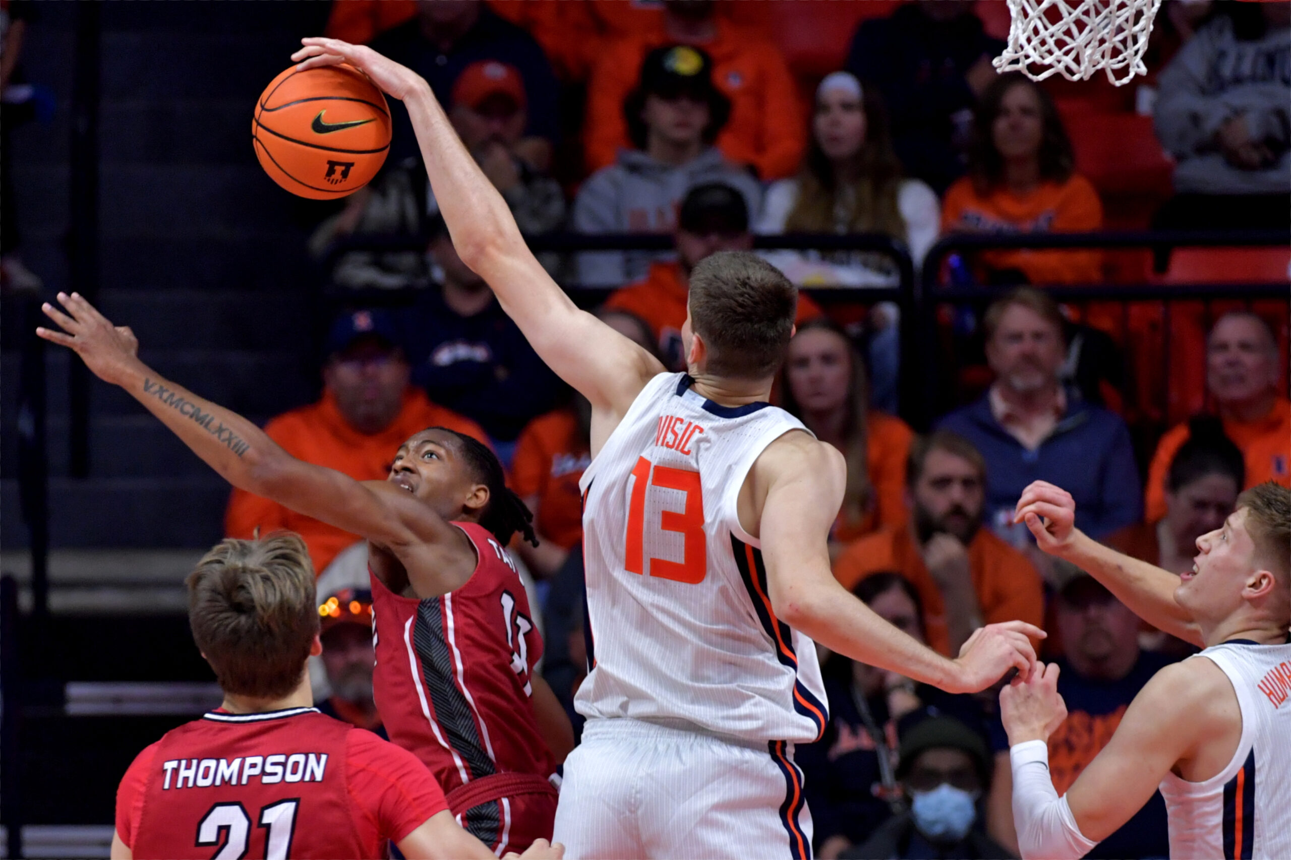 Nov 8, 2024; Champaign, Illinois, USA; Illinois Fighting Illini center Tomislav Ivisic (13) blocks a shot by SIU Edwardsville Cougars guard Brian Taylor II (11) during the first half at State Farm Center. Mandatory Credit: Ron Johnson-Imagn Images