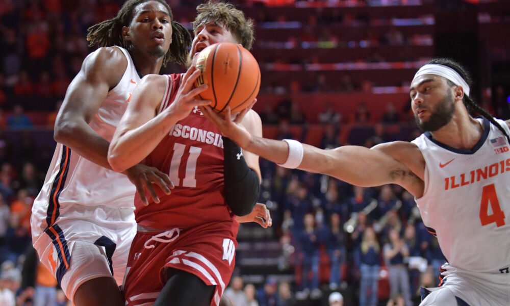 Dec 10, 2024; Champaign, Illinois, USA; Illinois Fighting Illini guard Kylan Boswell (4) reaches for the ball as Wisconsin Badgers guard Max Klesmit (11) drives to the basket during the second half at State Farm Center. Mandatory Credit: Ron Johnson-Imagn Images