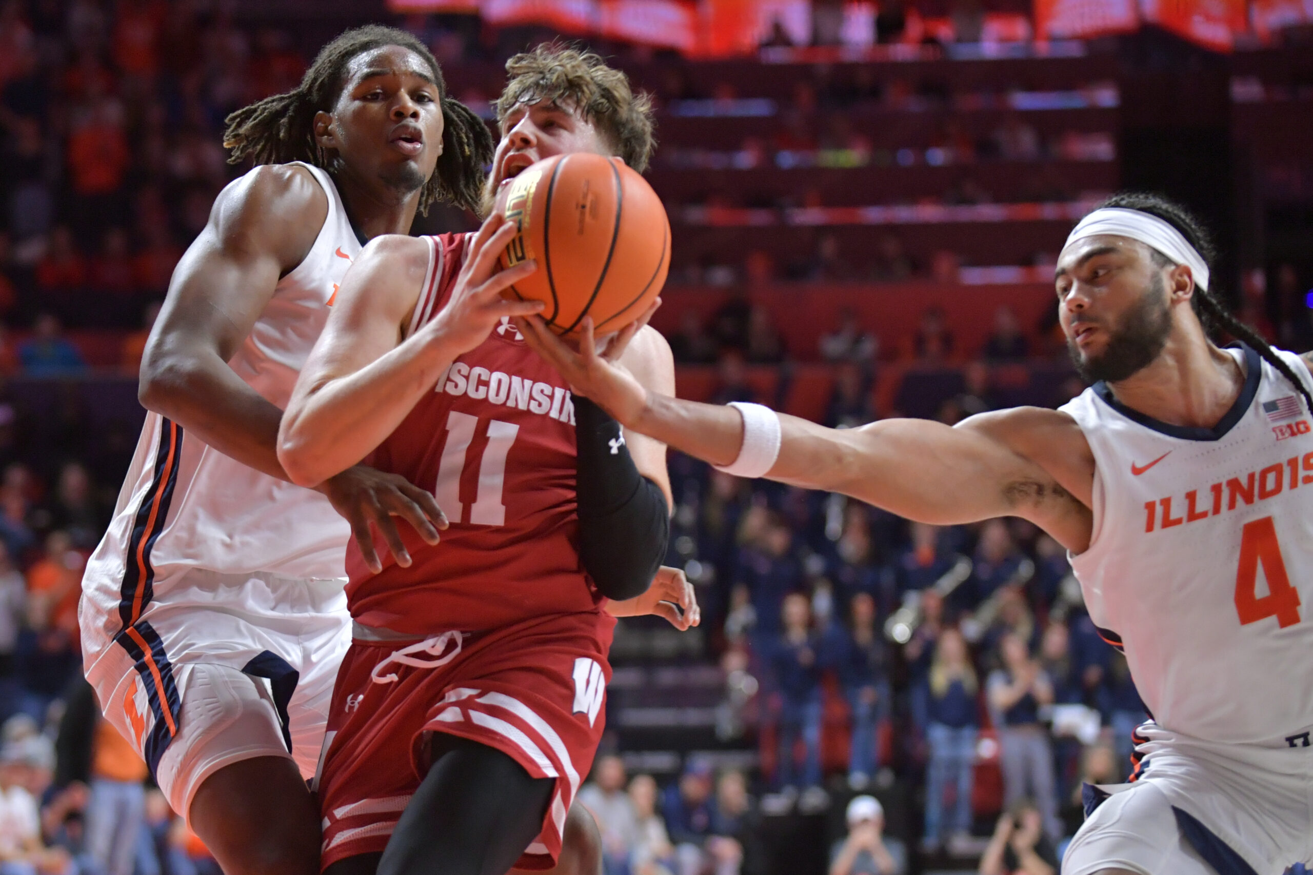 Dec 10, 2024; Champaign, Illinois, USA; Illinois Fighting Illini guard Kylan Boswell (4) reaches for the ball as Wisconsin Badgers guard Max Klesmit (11) drives to the basket during the second half at State Farm Center. Mandatory Credit: Ron Johnson-Imagn Images