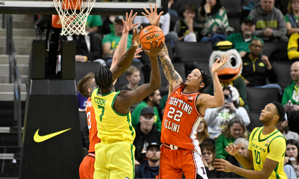 Jan 2, 2025; Eugene, Oregon, USA; Illinois Fighting Illini guard Tre White (22) and center Tomislav Ivisic (13) defend a shot by Oregon Ducks forward Supreme Cook (7) during the second half at Matthew Knight Arena. Mandatory Credit: Craig Strobeck-Imagn Images